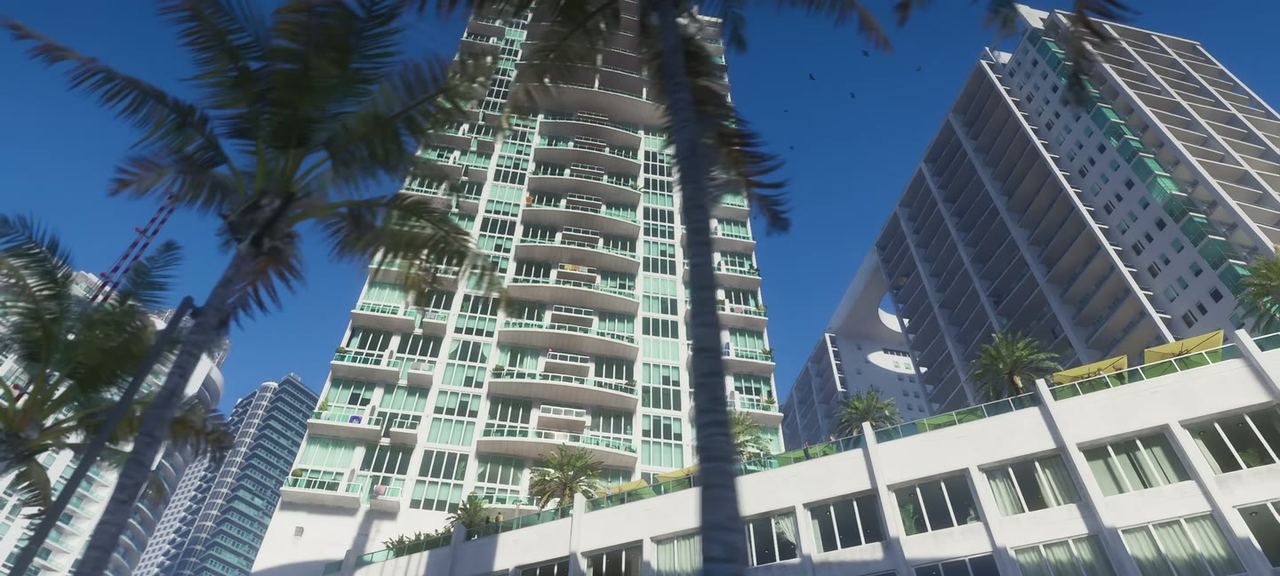 Waterfront towers from street level, palms in front. Vice City's residential high-rise stock.