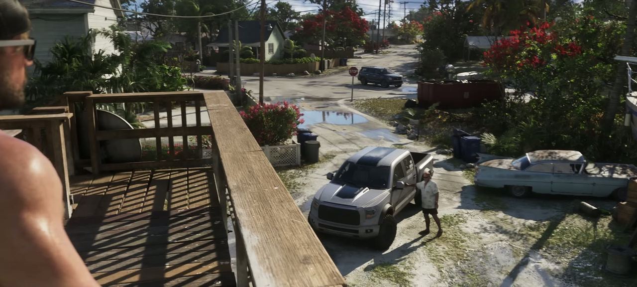 The bed of a pick-up, boats and yard beyond.