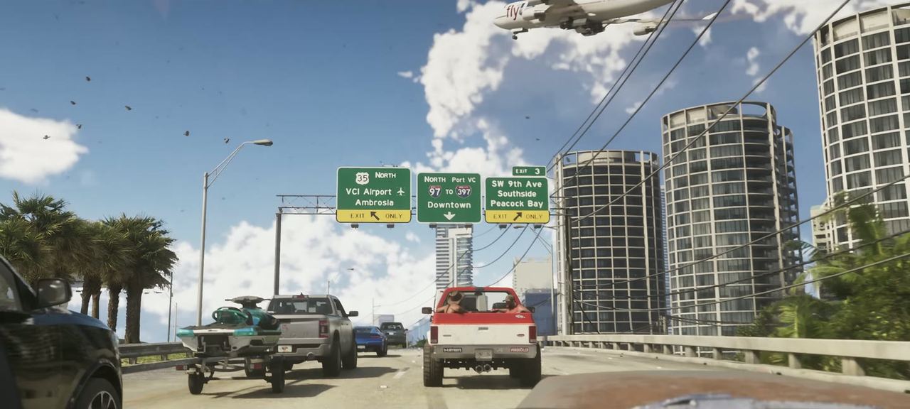 The causeway, with three overhead signs naming VCI Airport, Ambrosia, Port VC, Downtown, SW 9th Ave, Southside and Peacock Bay. A pick-up ahead tows a jet ski.