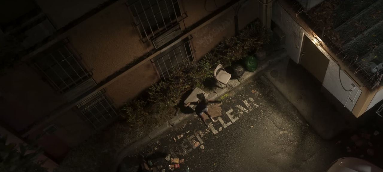 Aerial straight down onto a rooftop and an alley.