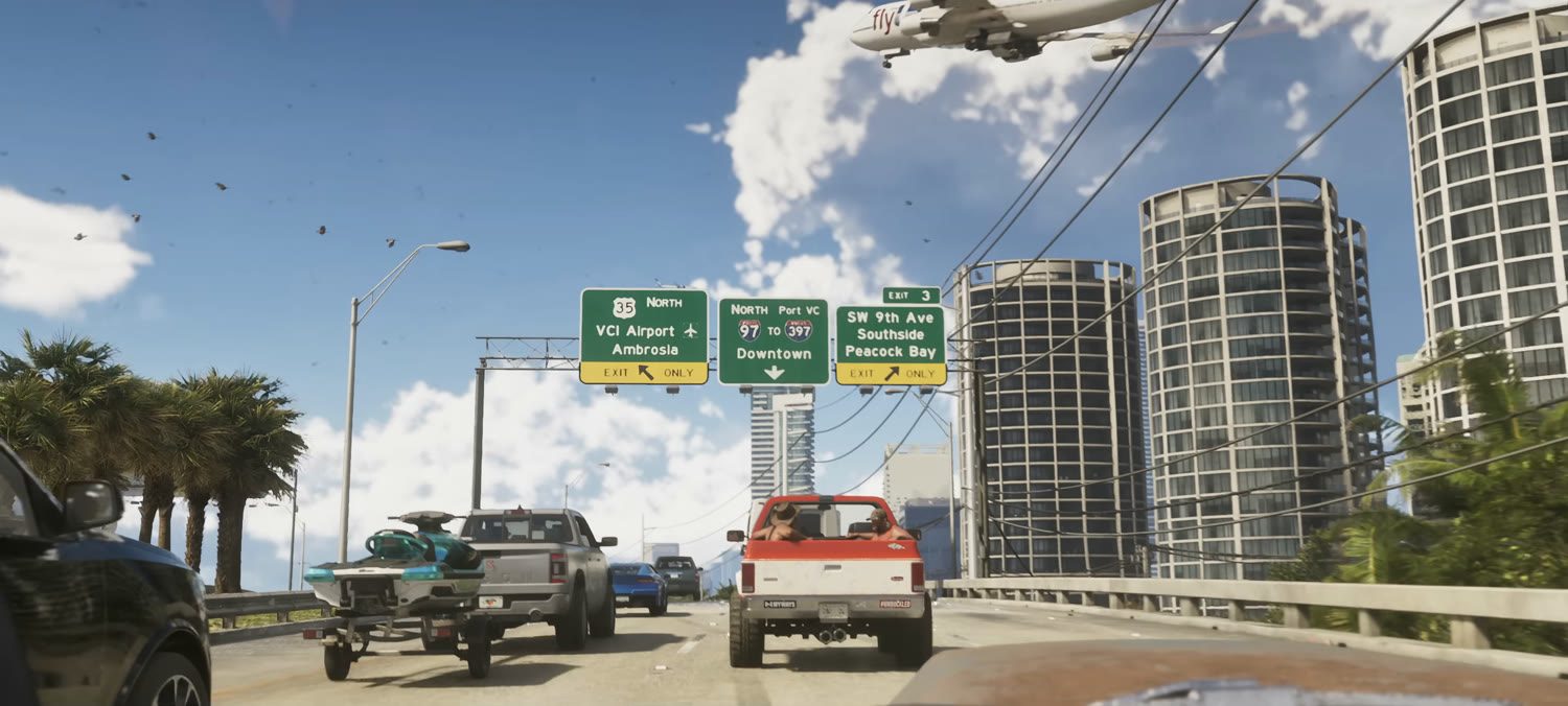 The full frame. The signs sit over a causeway heading into the city, with a jet ski on a trailer in the next lane